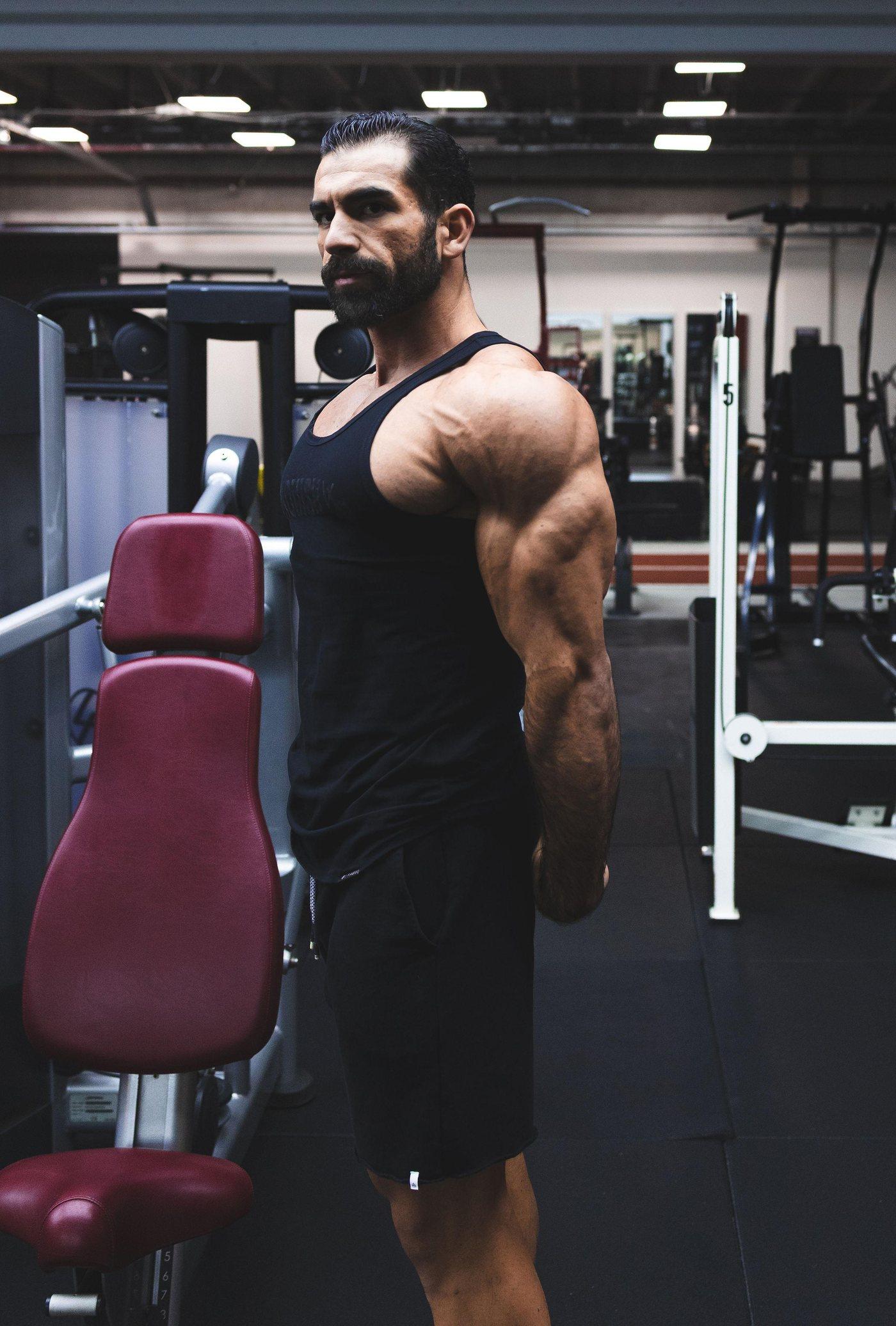 Abdullah Aziz standing on the gym floor in a black tank top