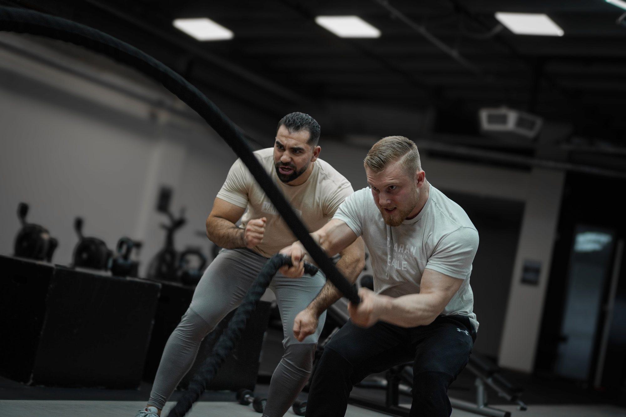 Abdullah coaching a client through battle-rope work