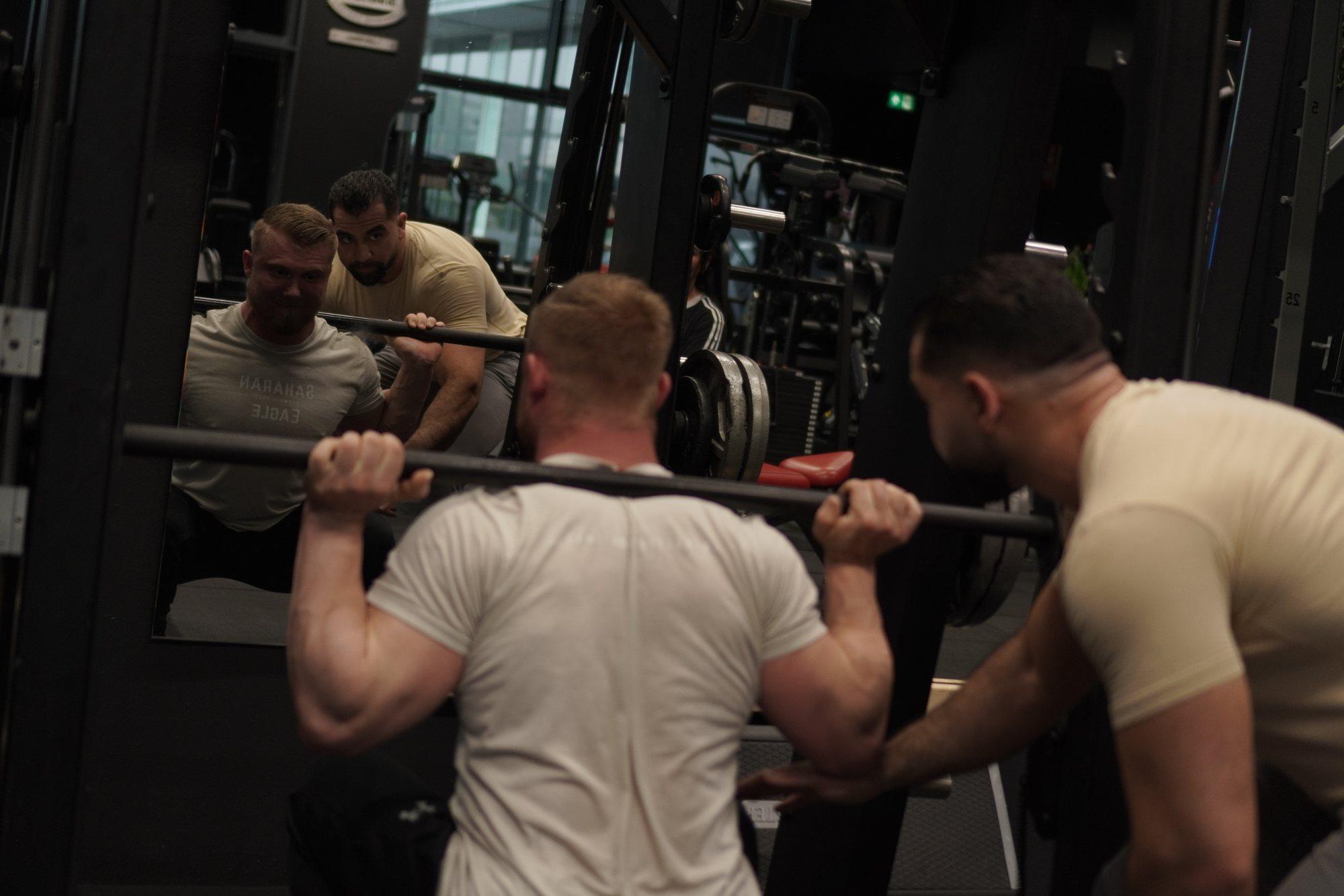 Abdullah spotting a client's barbell squat